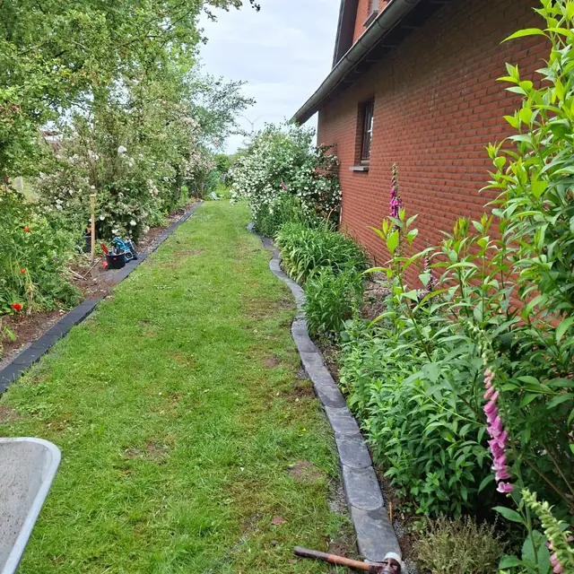 Gartenpflege entlang einer Hauswand
