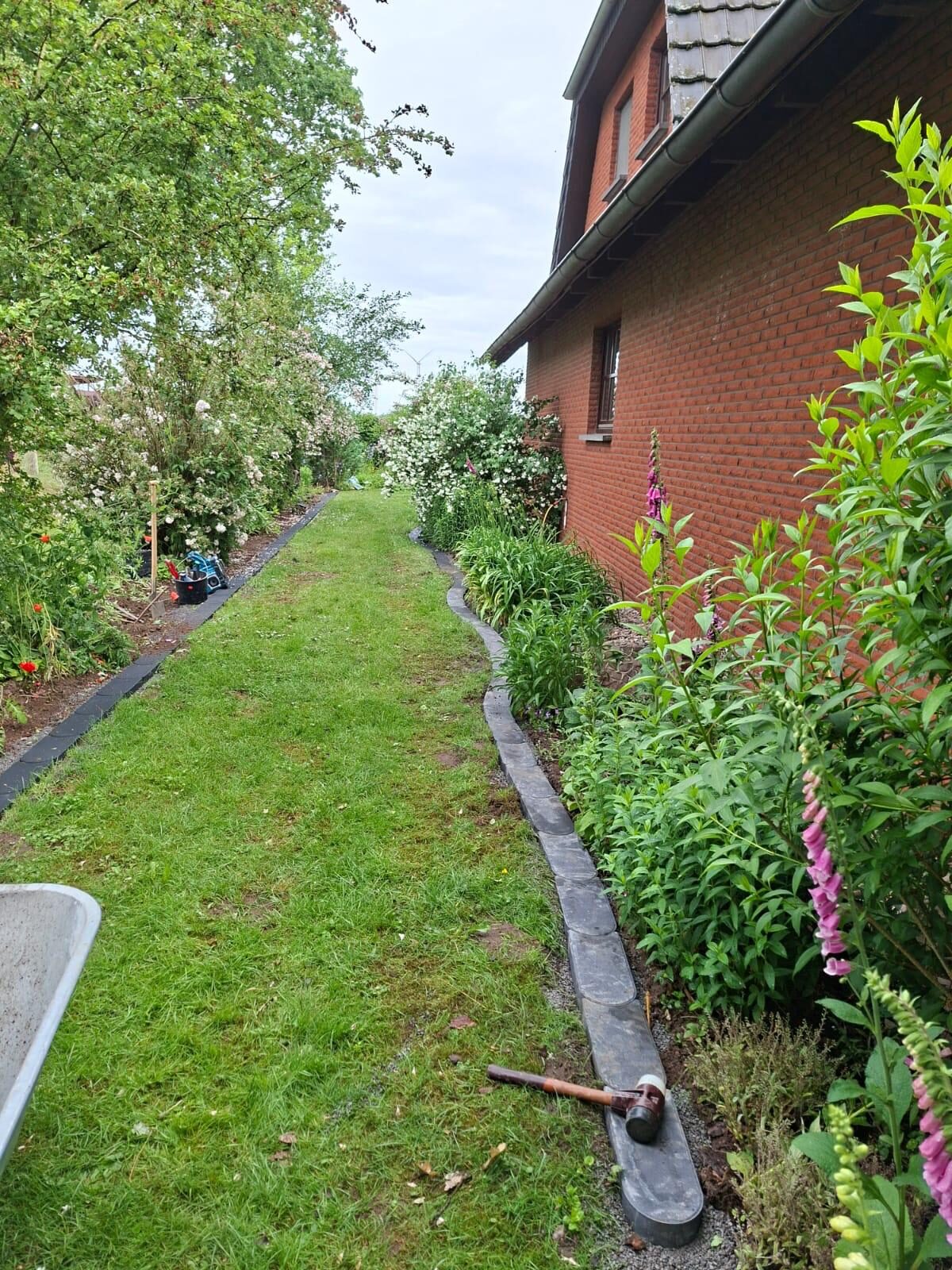 Gartenpflege entlang einer Hauswand