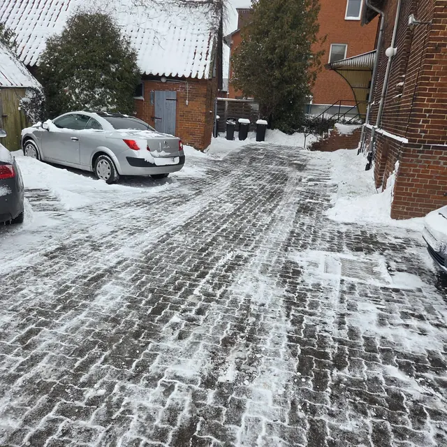 Räumfahrzeug beim Winterdienst auf verschneiter Fläche